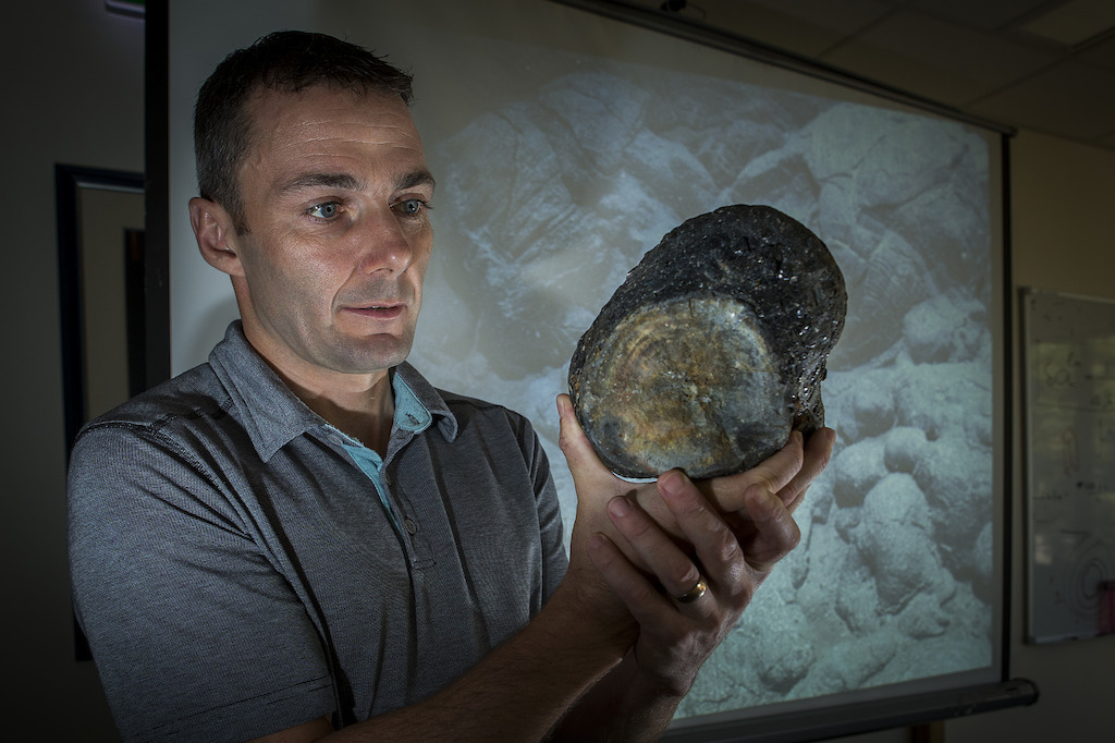 Dr Mark Kendrick with a sample of volcanic glass. Image: Stuart Hay, ANU.