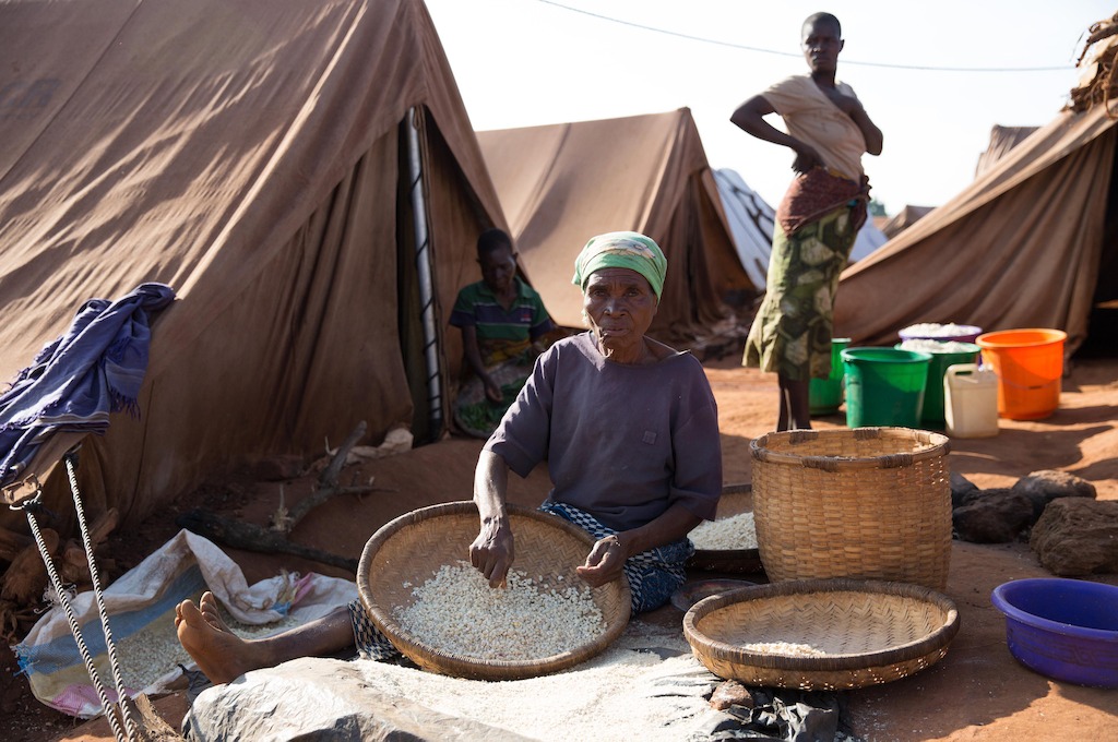 A woman prepares maize in the Kapise 2 settlement. Over 5.800 Mozambican nationals have camped in the village of Kapise 2 in Malawi after fleeing their homes in Mozambique, the majority of them women, children and the elderly. They are living in precarious conditions well below internationally recognized humanitarian standards. © James Oatway / MSF