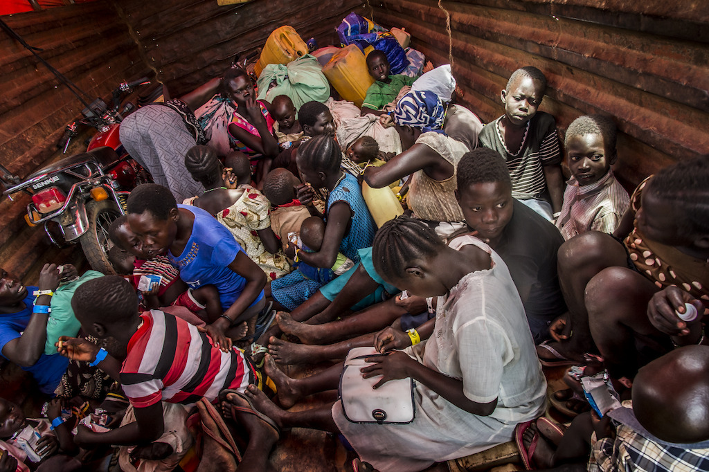 On various points of entry along the border of South Sudan. The refugees are welcomed, fed and as quickly as possible drive by bus to the reception center of Imvepi, located two-hour drive away from there. Photographer: Frederic Noy