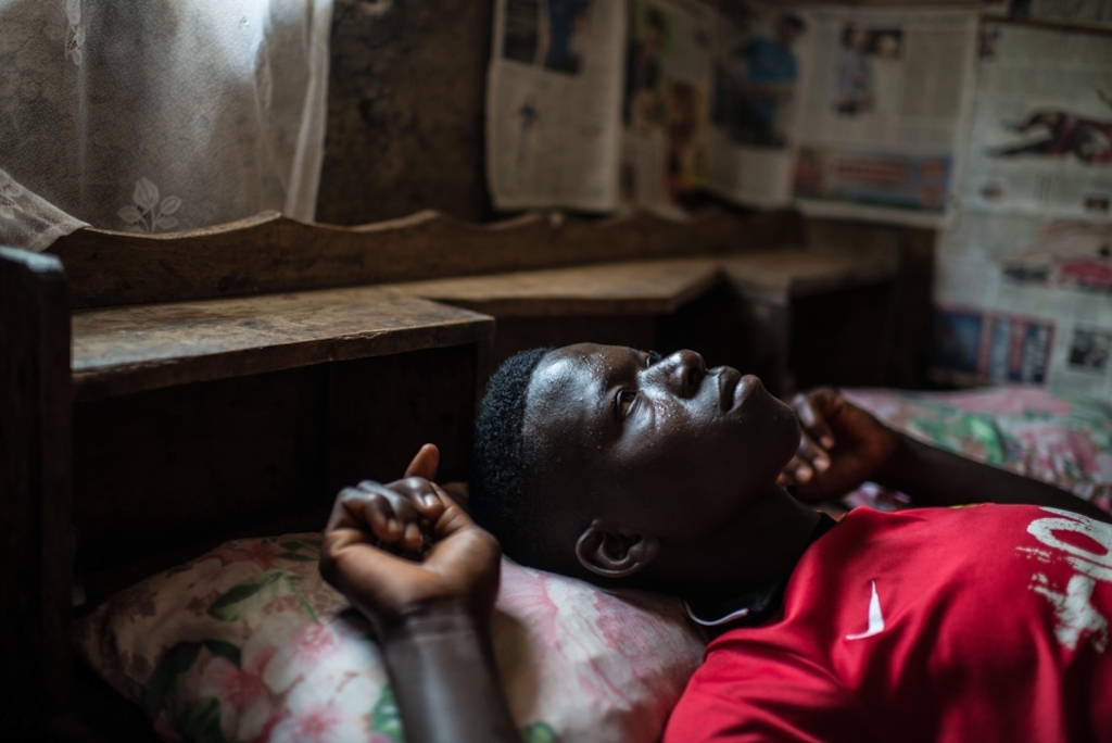 System identifier<br/>: MSF156328<br/>Title<br/>: Ebola Survivor Health in Tonkolili, Sierra Leone, Oct 2015<br/>Photographer / cameraman<br/>: Tommy Trenchard<br/>Countries:<br/>Sierra Leone<br/>Description<br/>: Ebola survivor Sorie Kamara photographed in his house during a MSF outreach mission<br/>the village of Mabekoh. Kamara, 25, used to farm rice and cassava before he caught Ebola but is now<br/>too weak. “I got Ebola in October last year. They took me to Bo and I was inside for 10 days. I felt so<br/>happy when I survived, but then three months later I stated to feel pain in my chest and my joints. I<br/>feel so weak