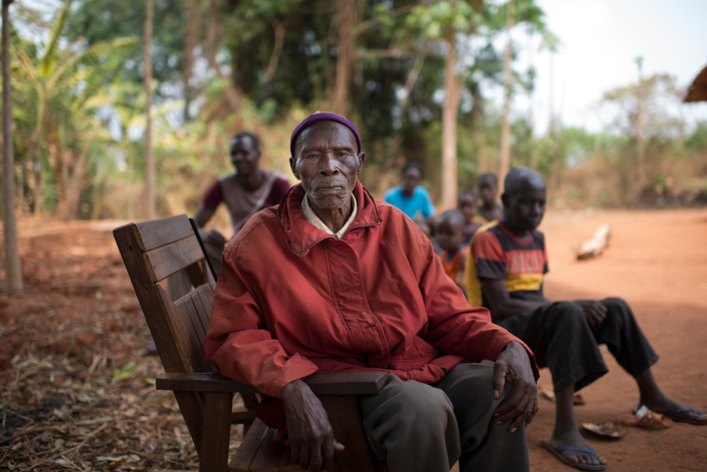 Henri Passendro, 84, chief of Nasima village, left Nasima on 6 Decembre 2016 with his family to find shelter at Aviation IDP camp. “The were infighting between UPC and FPRC near the village, a rumour said they were burning villages, so we fled. My son went back later to see what was left. All had been burned down. I would like to go back to my village, but I have no money left to pay transportation”. His son provides for Henri’s survival. Photographer: Colin Delfosse/Ouf of Focus