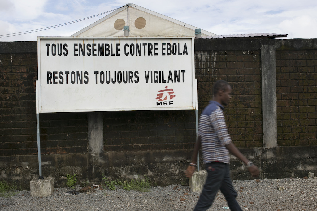 Outside the Medecins Sans Frontieres (MSF) health facility in Nongo. <br/><br/>A sign reads (in french): 'Tous Ensemble Centre Ebola Restons Toujours Vigilant'<br/>("All together against Ebola, always remain vigilant"). Photographer: Albert Masias