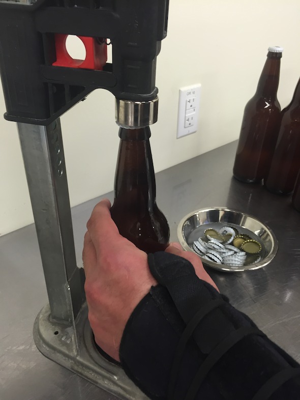 Bottles filled with Worth the Wait Cantaloupe Gose are capped.