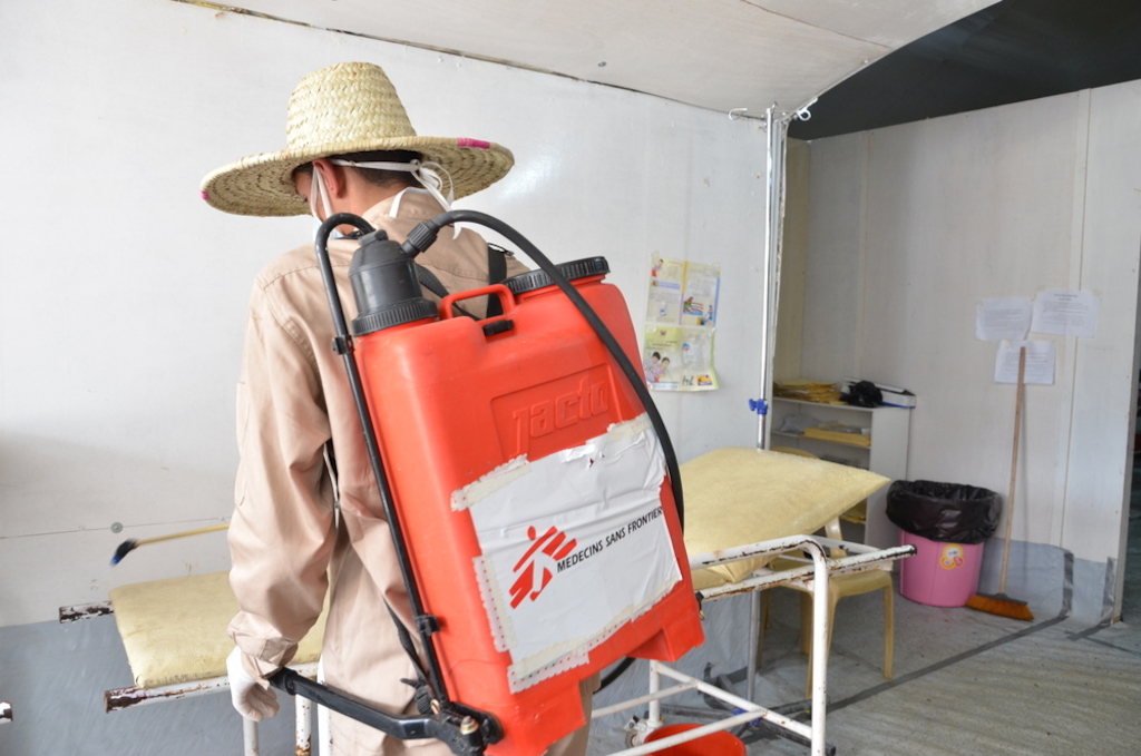 MSF cleaner while spreading chlorination on a bed that has been just emptied after a patient was referred to the inpatient department at MSF cholera treatment center in Khamer. Chlorination of beds is one of the precautions taken to stop the spread of cholera. Photographer: Nuha Haider/MSF