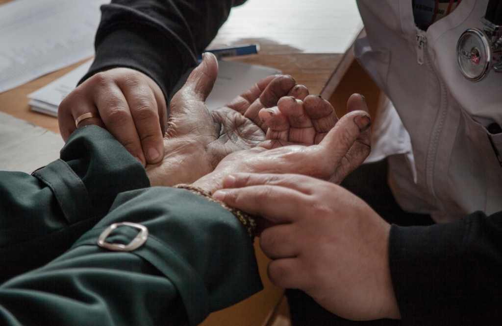 System identifier: MSF145431<br/>Title: Mobile Clinic in Gorozishe, Lugansk<br/>Photographer / cameraman: Jon Levy<br/>Countries: Ukraine<br/>Description: Dr Moshin Mehraj checks the pulse of an elderly patient at the MSF mobile clinic in the village of Gorodishe, near Lugansk.