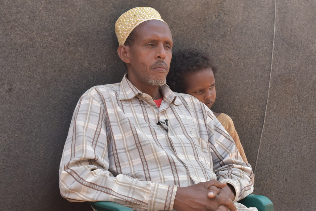 Mohamed Farah Abdi arrived in Dadaab in 1992. He is pictured with his seven year old disabled son. <br/><br/>“When we fled, I was still a small boy. I don’t see where I can go back to. I have fled from conflict, and now I have a disabled son who cannot even sit by himself. If I leave here, where will he get care? In Somalia, you will not find the services that we have here.<br/><br/>We will not be able to find proper health centres. If you are poor, you will require a lot of money to get healthcare. There are government hospitals to rely on for free medication.” Photographer: Mohamed Ali