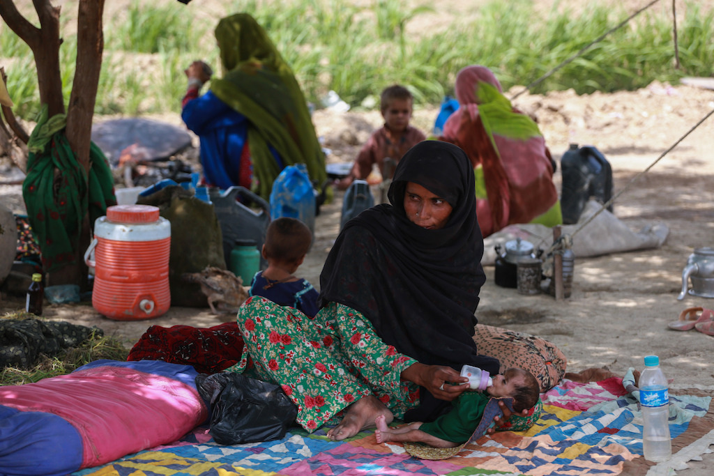 Bas Khatoon feeds formula milk to her 3 month old baby at her makeshift house in a village near Dera Murad Jamali in Balochistan, Pakistan. Photographer: Sara Farid