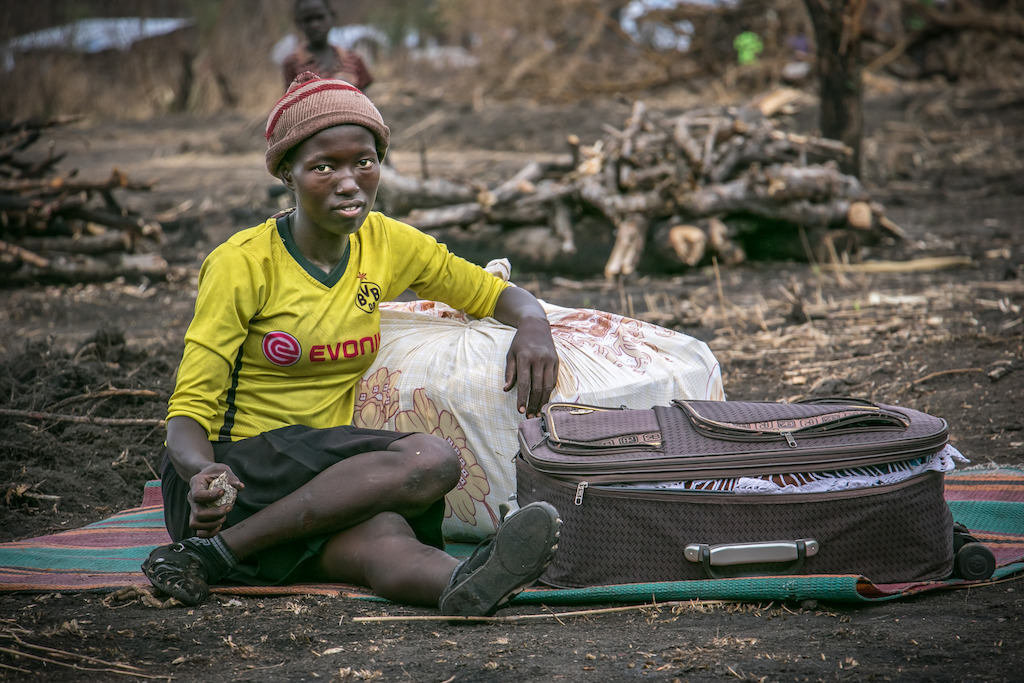 A refugee from Kajo Keju, South Sudan sits with her suitcase in Palorinya refugee camp, Uganda. Thousands have fled here from neighbouring South Sudan after fighting erupted, bringing only what they can carry. Photographer: Fabio Basone/MSF