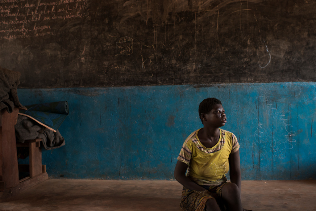 Catherine, 16, fled her village with her parents and her fourteen brothers and sisters after it was burned. They found shelter in the village of Ngoubi's school, 18km from Bria. Photograpaher: Colin Delfosse