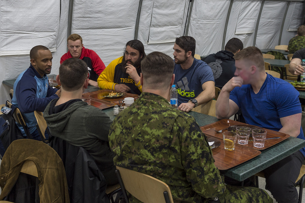 Matt Black (G), Andrew Buckley (C) et Mike Filer (D) discutent dans la mess avec des militaires déployés dans le cadre de l'opération UNIFIER à Starychi, en Ukraine. Photo : CplC Mathieu Gaudreault, Caméra de combat des Forces canadiennes