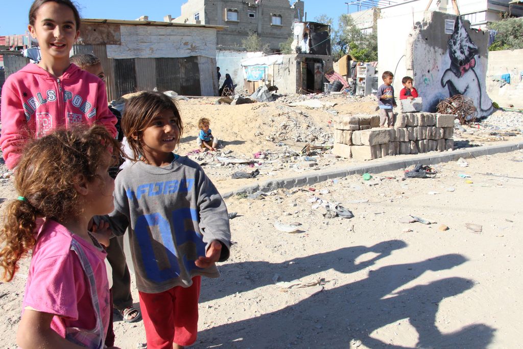 Beit Hanoun in north Gaza strip, severely hit by last war, still many destroyed houses - children of the neighbourhood in front of Banksy mural of the cat, near the UNRWA school which still hosts 53 families who lost their homes during Protective Edge. © Susanne Doettling/MSF