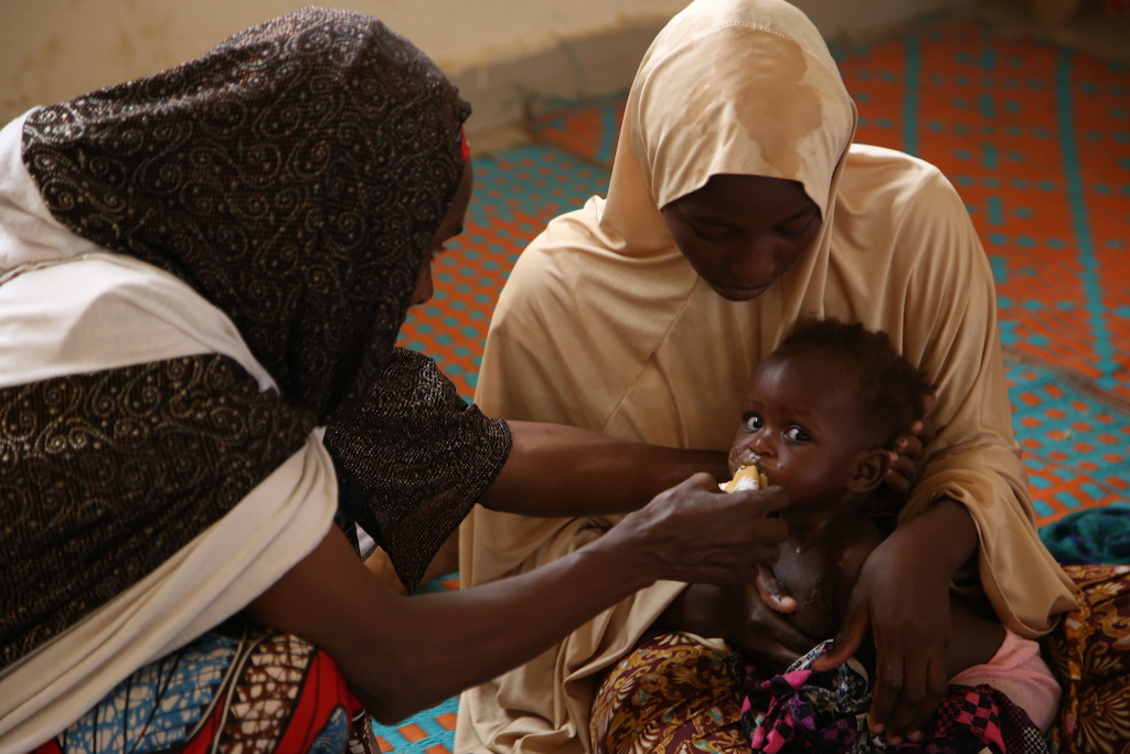 An MSF worker feeds a child in an MSF outpatient therapeutic feeding centre in the northeastern Nigerian town of Banisheikh. Photographer: Igor Barbero