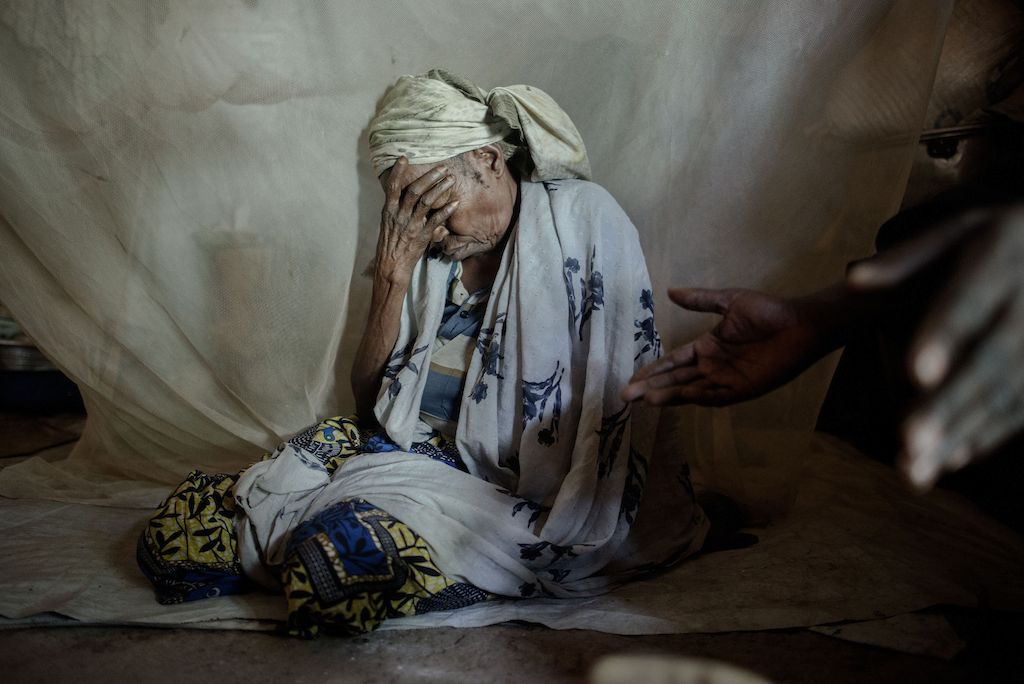 65 year old Amine at a at a camp for displaced people at the Central Mosque in Bangui.<br/><br/>Amina is from Bouca in the north of the country. One morning around 5am, armed groups surrounded her neighbourhood and pushed all Muslims inside a house and then set the house on fire. Amina was in a neighbour’s house watching the scene from the window. She was saved thanks to a Christian who protected and allowed her and some other mothers to escape. Amina found her four daughters and fled. One of her daughters paid for a ticket to go to Bangui while her daughters fled to Chad. That was three years ago, Amina often calls her daughters who now live in a refugee camp in Chad. Hachta (40), Apsita (35) and Kadidja (28) are healthy but have not been able to find work. Mariam (30), her fourth daughter died at his arrival in the camp following an illness. Amina would like to join her daughters but due to lack of money, she cannot. Today Amina survives thanks to the solidarity of the displaced families in the mosque, and the distribution of food in the camp.
