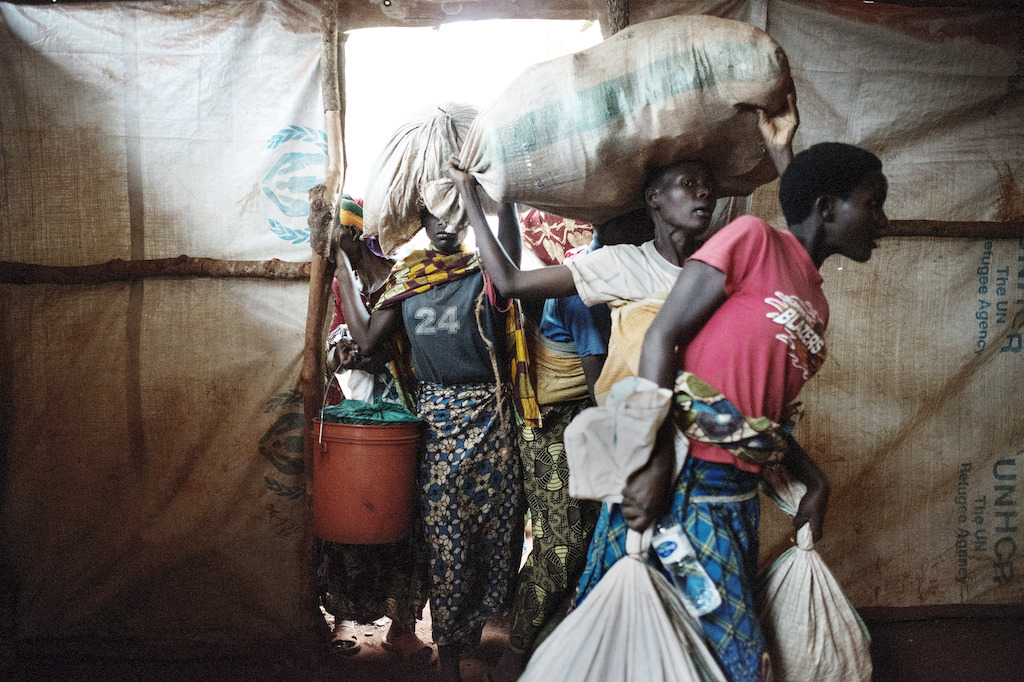 Newly arrived Burundian refugees enter the tent where they will stay in Nyarugusu. During the last weeks, the camp has received hundreds of new refugees every day. Photographer: Luca Sola