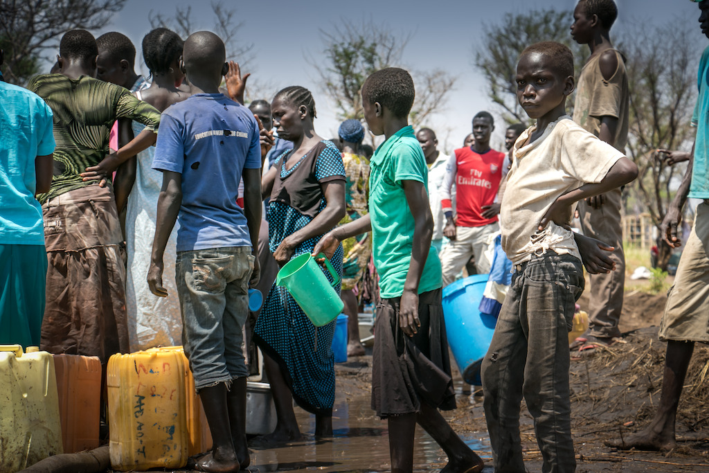 A water truck is stuck in the mud in Palorinya refugee camp, Uganda.<br/><br/>People take the opportunity to get much needed water when a water truck gets stuck in the mud after heavy rain. The impending rainy season will only make the situation worse as vehicles struggle to get around the camp. Photographer: Fabio Basone/MSF