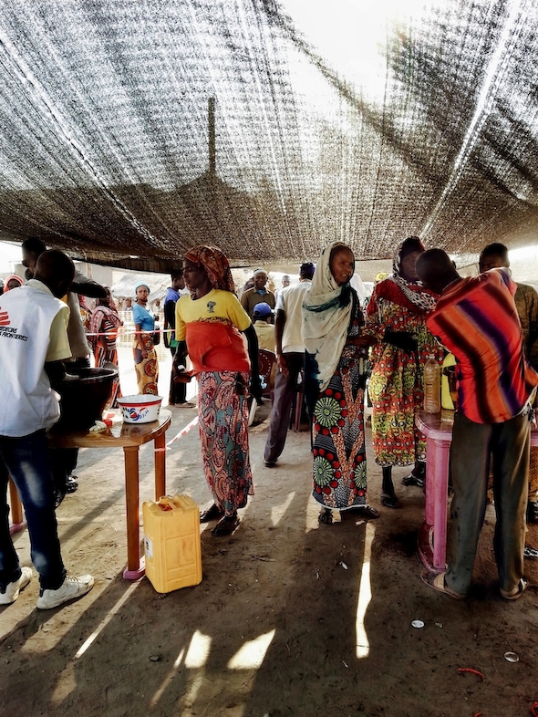 Women stand in line to receive donations of rice, beans,oil, salt and sugar from MSF teams. Photographer: MSF