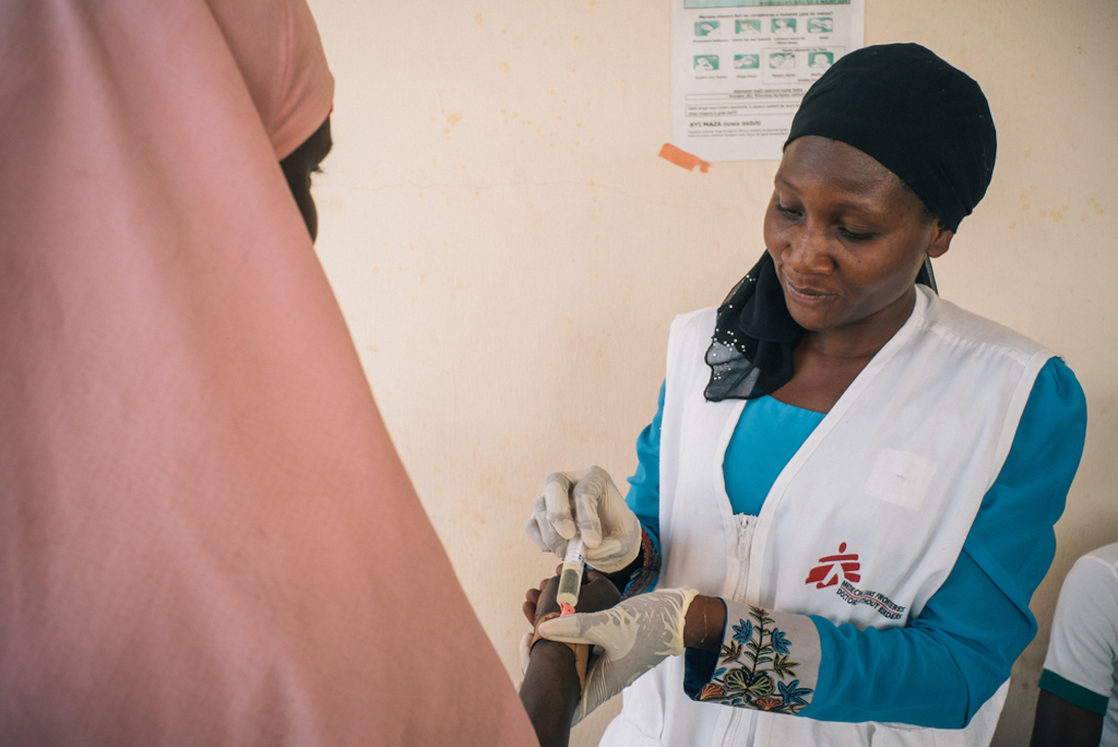 Member of MSF Nigeria Emergency Response Unit (NERU) attends a woman in the meningitis treatment center run by MSF in Sokoto Mutalah Mohamad Hospital. Photographer: Fabrice Caterini - INEDIZ/MSF